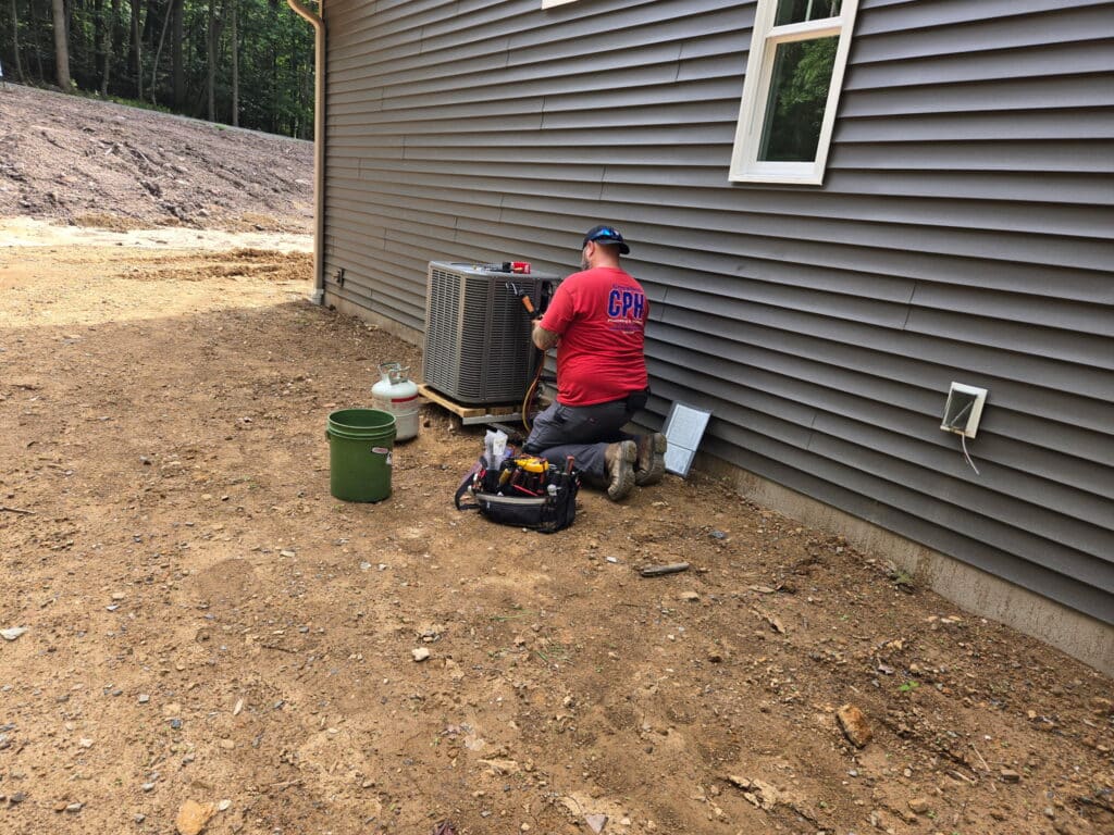 Technician installing an AC condenser in Denver, PA