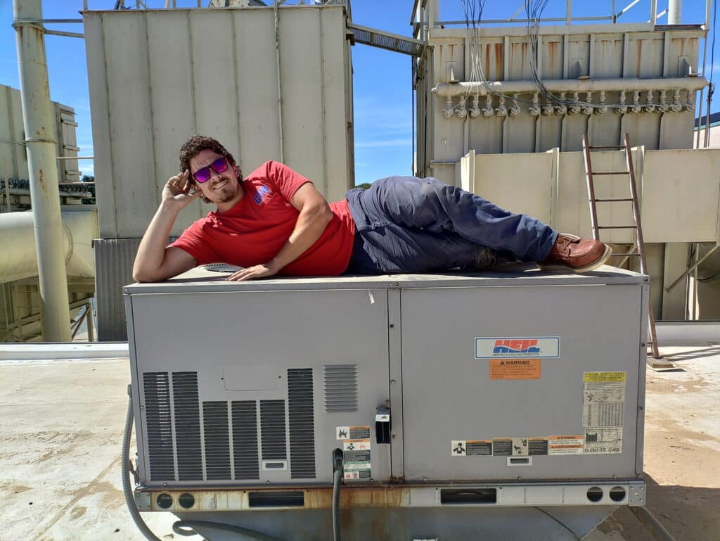 Technician on a commercial rooftop HVAC unit in Denver, PA
