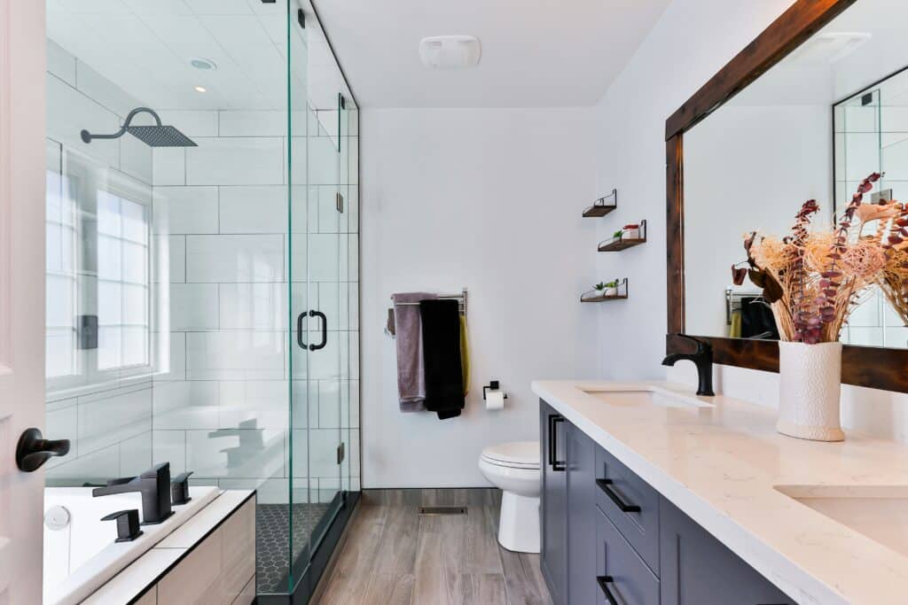 Remodeled bathroom with glass shower and double vanity