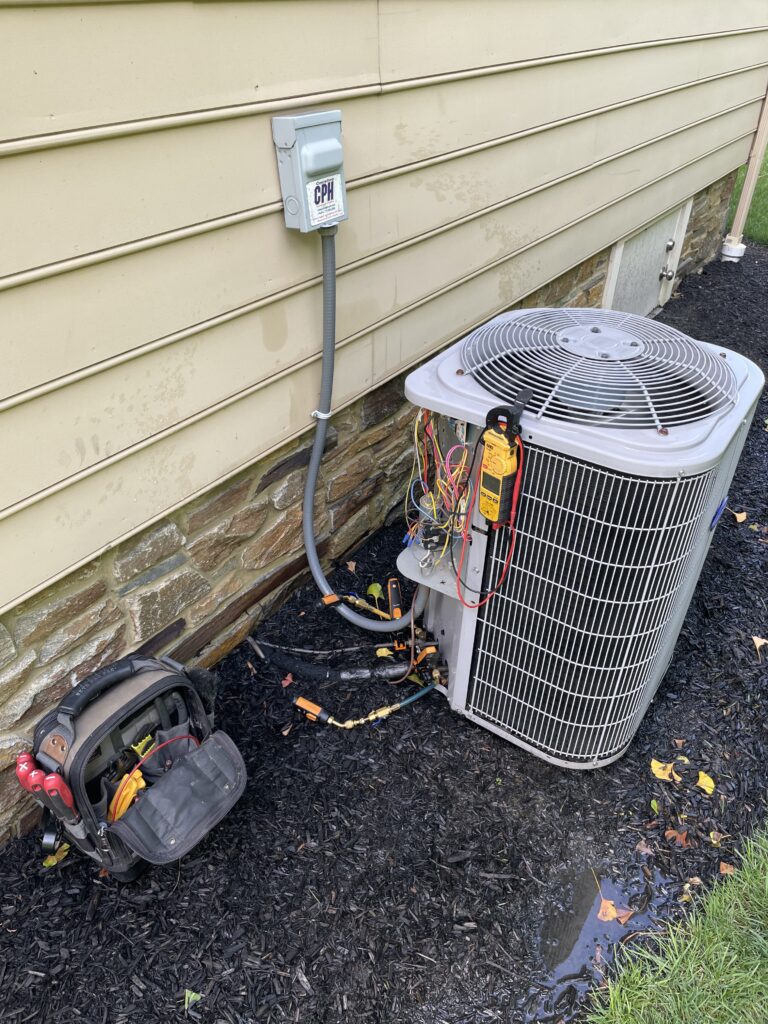 Outdoor AC condenser unit beside a home