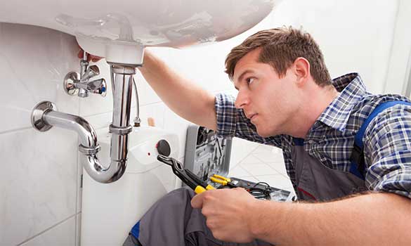 Plumber repairing a bathroom sink drain