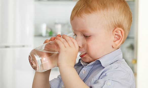 Child drinking a glass of clean filtered water
